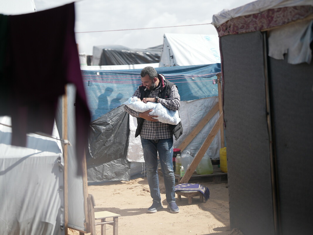 Fedaa tiene in braccio suo figlio a Rafah. Il bambino è nato in una tenda e fa parte dei 50 mila neonati nati a Gaza negli ultimi mesi. Photo credits: Alef Multimedia/Oxfam 