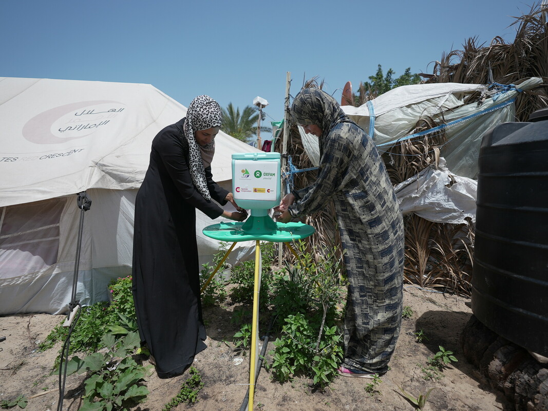 Due donne sfollate utilizzano uno dei lavabi installati nel campo di Al Mawasi. Foto: Alef Multimedia/Oxfam 